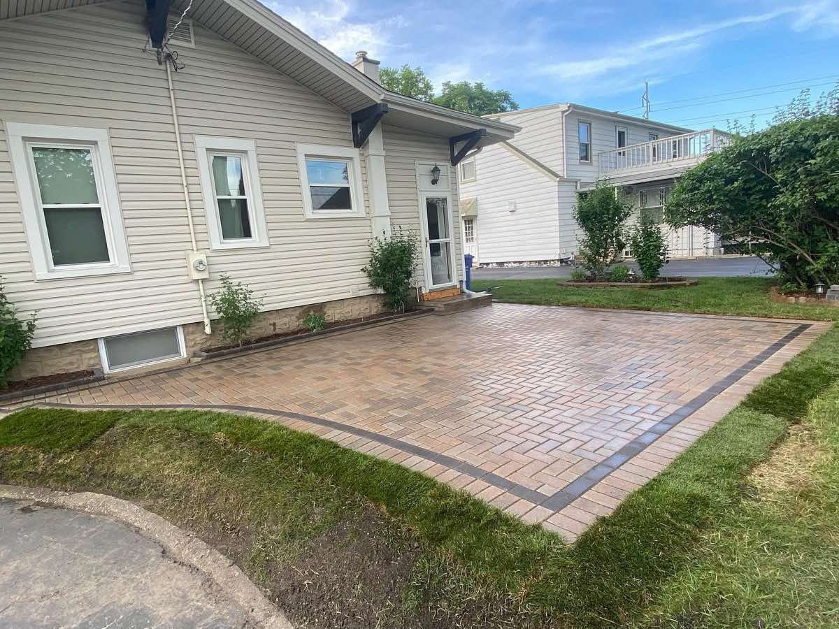Finished paver patio with dark double border replacing the lawn