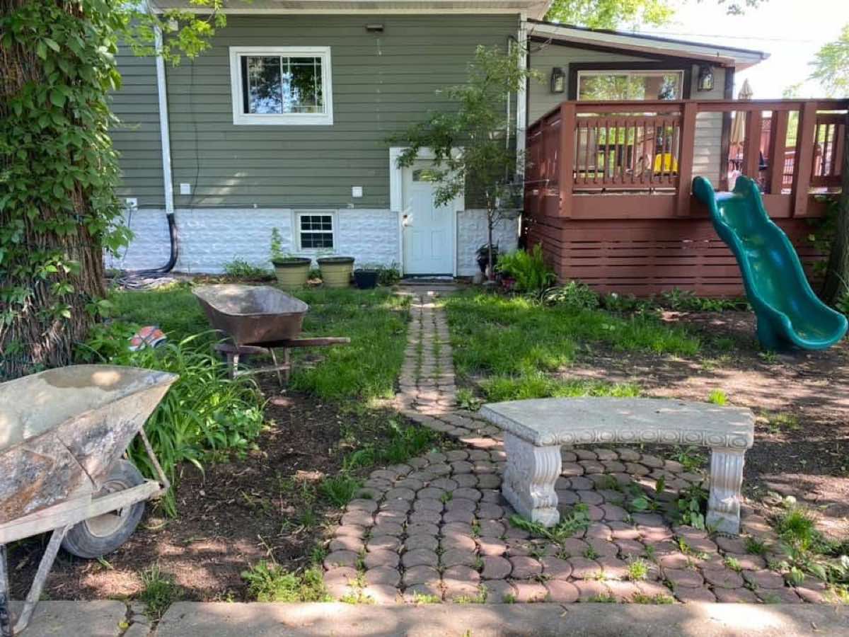 Old weedy round-paver path through patchy backyard before renovation